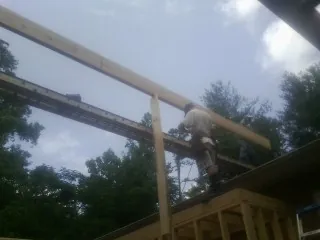 Carpenter setting a ridge beam over a new addition frame — Ice Dam Removal by Roofing Brothers in Villa Ridge