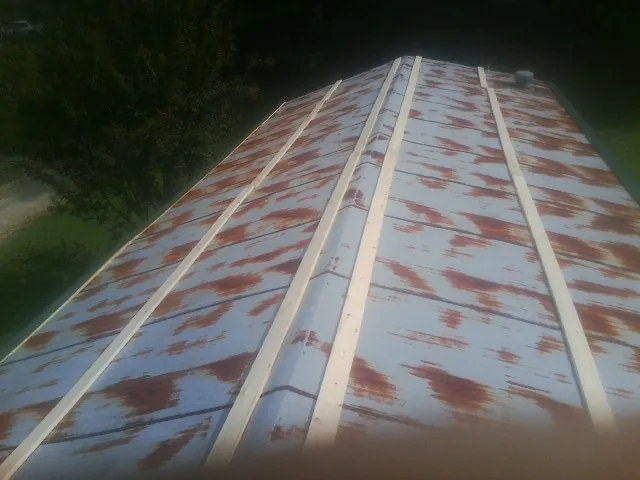 Rusted metal roof panels with new wood purlins before replacement — Storm Damage Roof Repair in Villa Ridge by Roofing Brothers