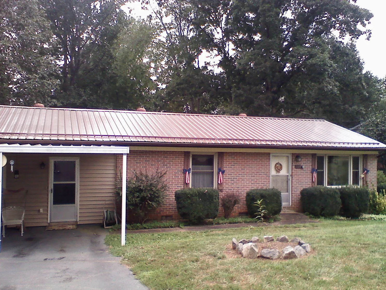 Bronze metal roof and carport on a brick ranch home — Roof Repair work by our crew in Villa Ridge