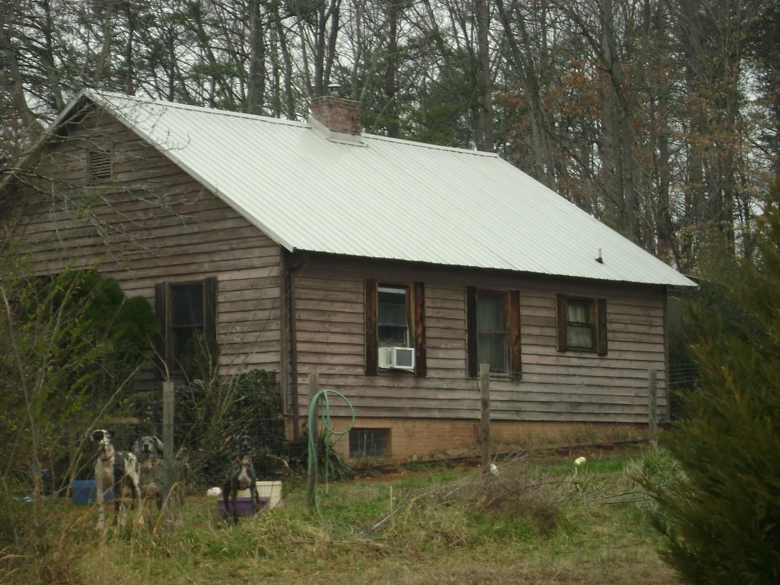 White metal roof on an old wood sided farmhouse, from a Metal Roof Installation job in Villa Ridge
